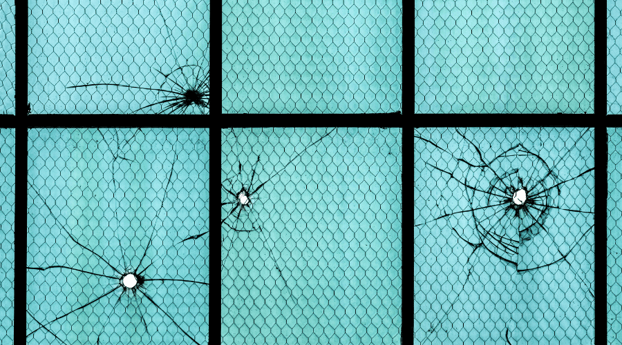 Photograph of bullet holes in the window of hangers.